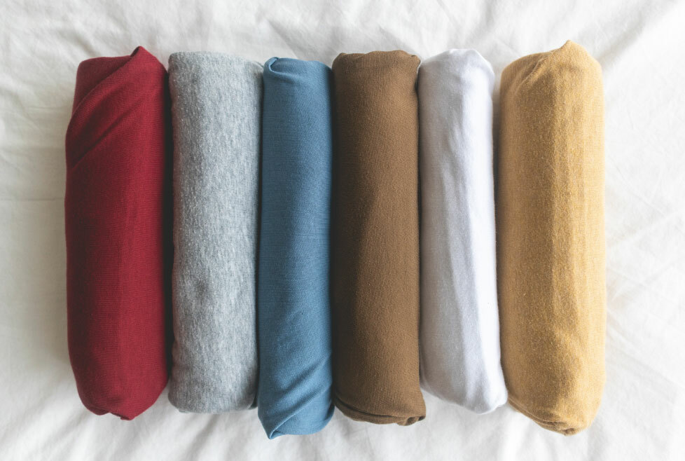 [image-08: Assortment of different cotton knit fabrics showing varying weights and structures, including jersey, rib knit, and French terry]