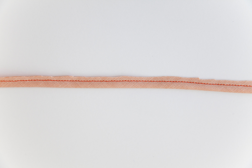 cutting excess fabric from rouleau button loops