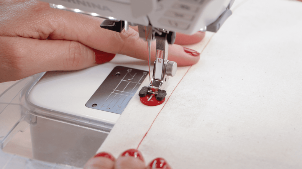 Button foot attached to sewing machine with button positioned underneath